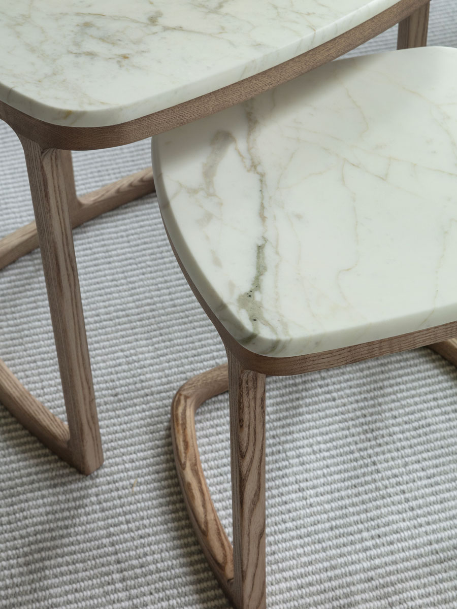 Porada_antigone_designEG_web La table ronde Saddle pour Porada, plateau en verre et piétement en bois